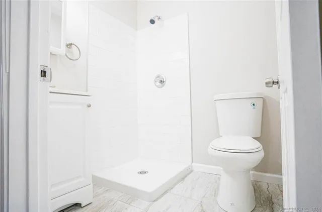 a bathroom with a toilet and a shower