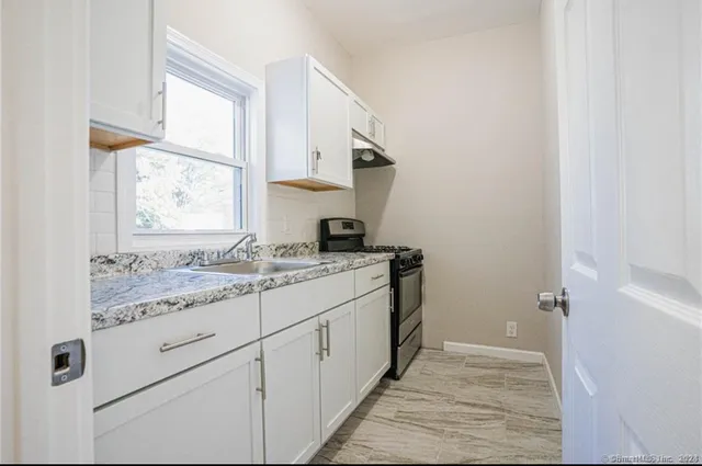 a bathroom with a granite countertop sink and a window