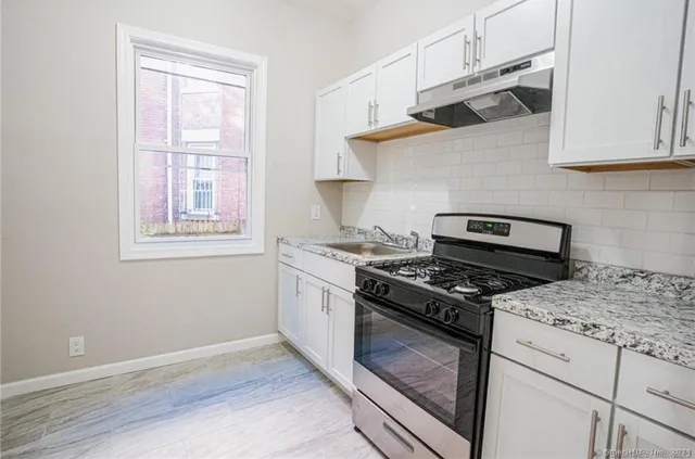 a stove top oven sitting inside of a kitchen