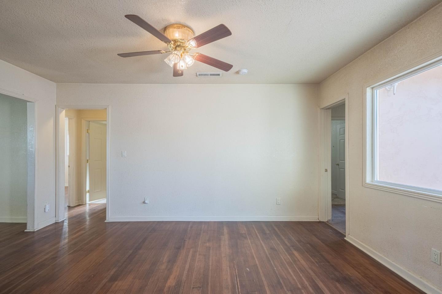 40 Oak Street Salinas, CA 93901 - Photo 7 of 28 an empty room with wooden floor and a ceiling fan