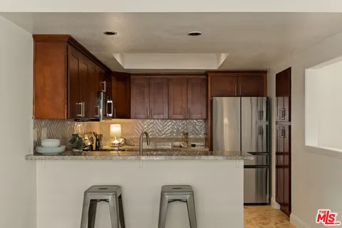 a kitchen with stainless steel appliances granite countertop a refrigerator and a sink