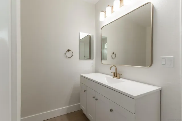 an empty room with a empty space and a kitchen view