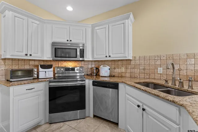 a kitchen with granite countertop a sink and cabinets