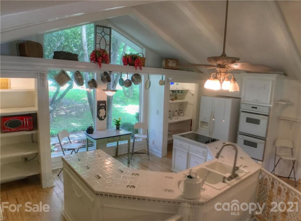 3956 Lake Shore Road South Denver, NC 28037 - Photo 14 of 44 a room with lots of white furniture a chandelier and a large window