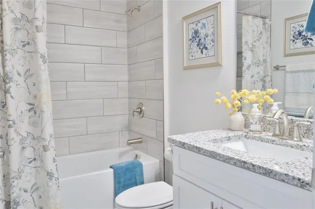 a bathroom with a granite countertop toilet sink and bathtub