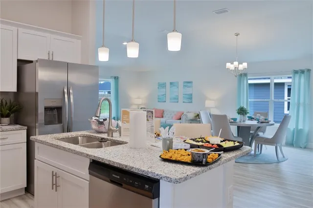 a kitchen with sink refrigerator and cabinets