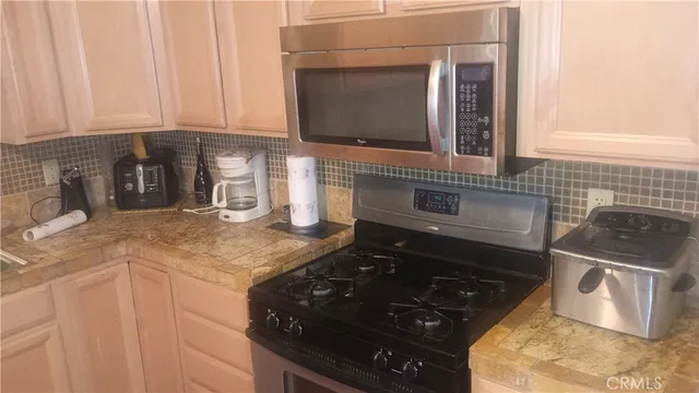a kitchen with stainless steel appliances granite countertop a sink and a stove