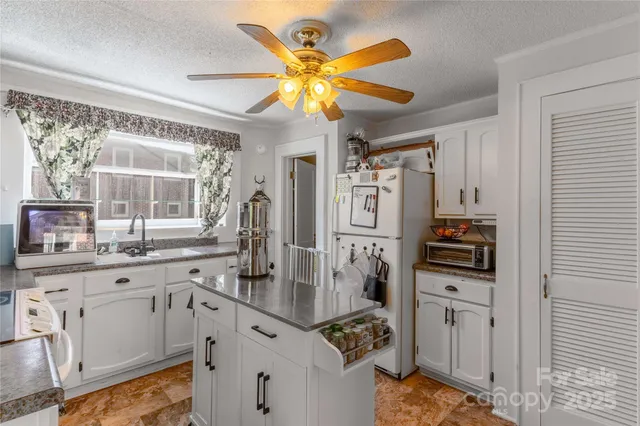 a kitchen with stainless steel appliances granite countertop a sink a stove top oven a counter space and cabinets