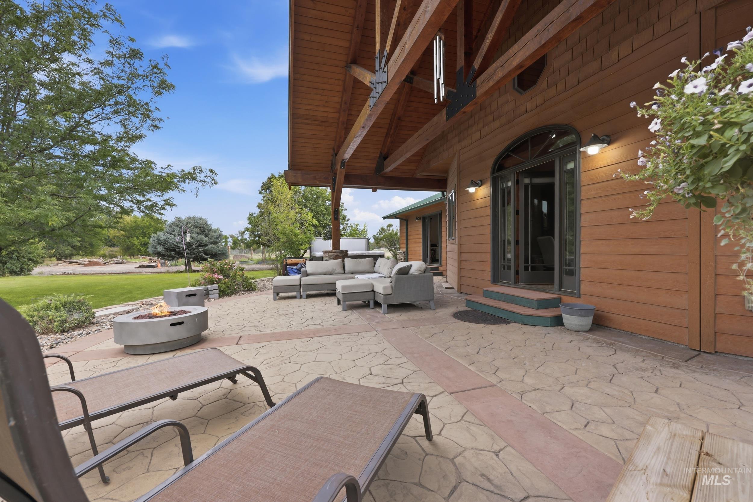339 Airport Road Weiser, ID 83672 - Photo 33 of 49 Expansive stamped concrete patio featuring a built-in fire pit and a covered porch with exposed wood beams