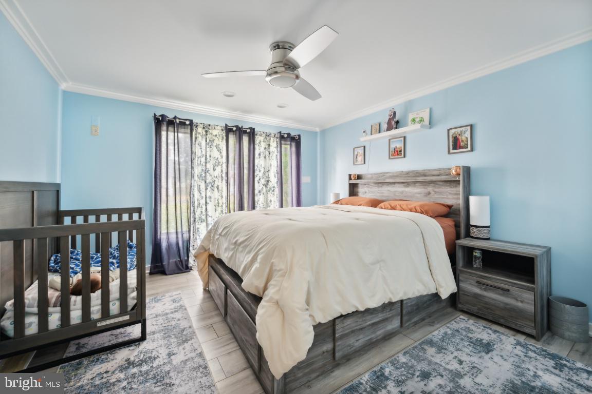 323 Palmer Street Riverside, NJ 08075 - Photo 17 of 30 a bedroom with a large bed and a chandelier