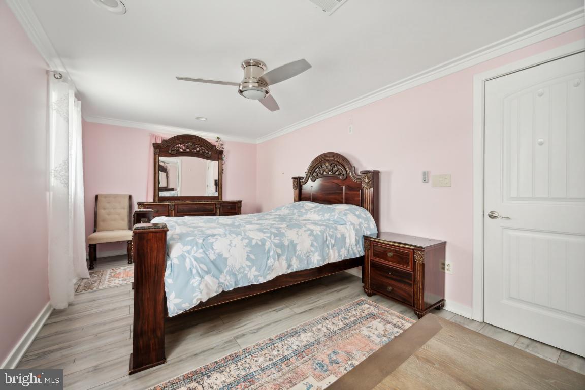 323 Palmer Street Riverside, NJ 08075 - Photo 20 of 30 a bedroom with a bed and a chandelier
