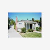 a view of a house with a yard and potted plants