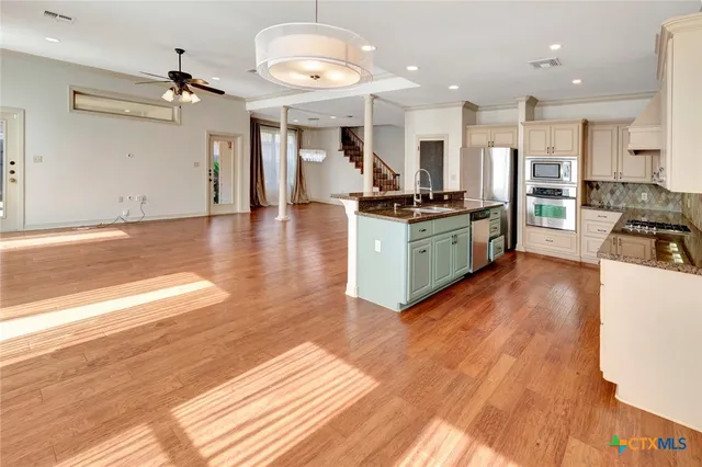 a large kitchen with stainless steel appliances granite countertop a large counter top and a stove
