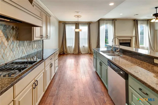 a kitchen with stainless steel appliances granite countertop a stove and a wooden floors