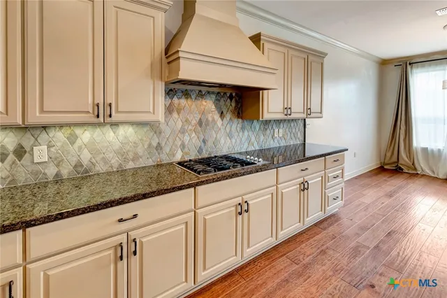 a kitchen with stainless steel appliances granite countertop a sink a stove cabinets and wooden floor