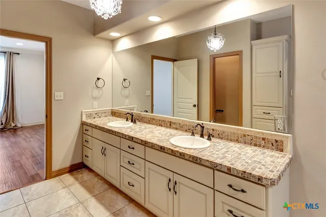 a bathroom with double sink and a mirror