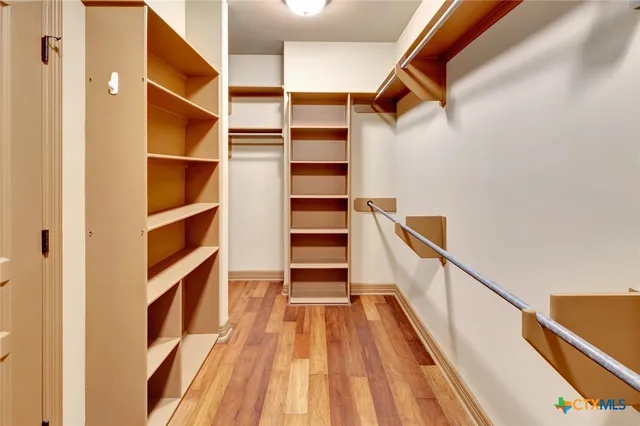 a view of walk in closet with empty racks