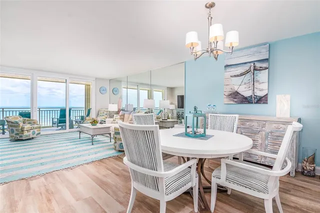 a view of a dining room with furniture a chandelier and wooden floor