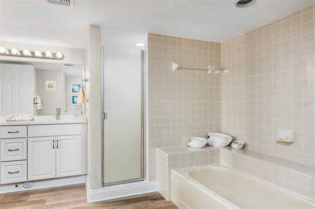 a bathroom with a tub a sink and a large mirror