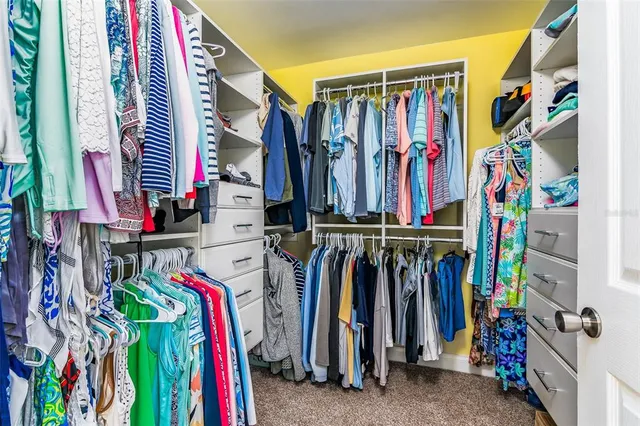 a view of walk in closet with clothes