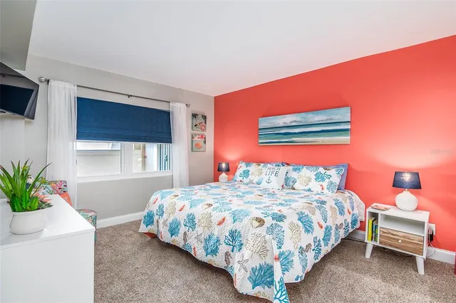 a bedroom with a bed and a potted plant