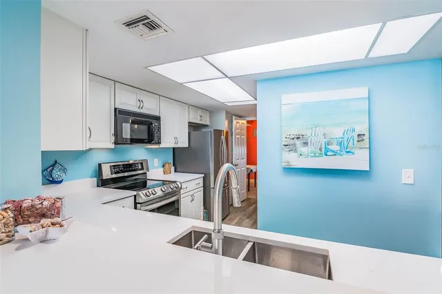 a kitchen with stainless steel appliances a cabinets a sink a window and a counter top space