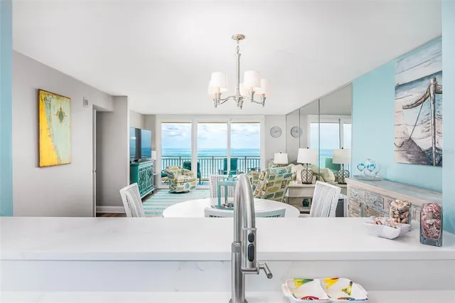a living room with furniture a large window and a chandelier