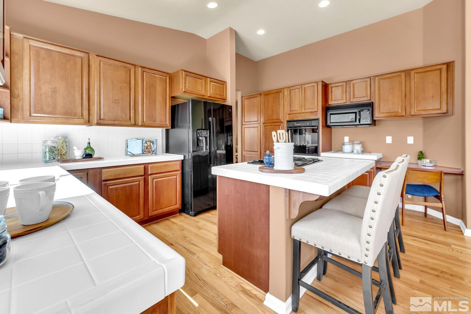 4965 Pinebluff Trail Reno, NV 89519 - Photo 18 of 40 a kitchen with stainless steel appliances kitchen island granite countertop a sink a stove a refrigerator cabinets and chairs