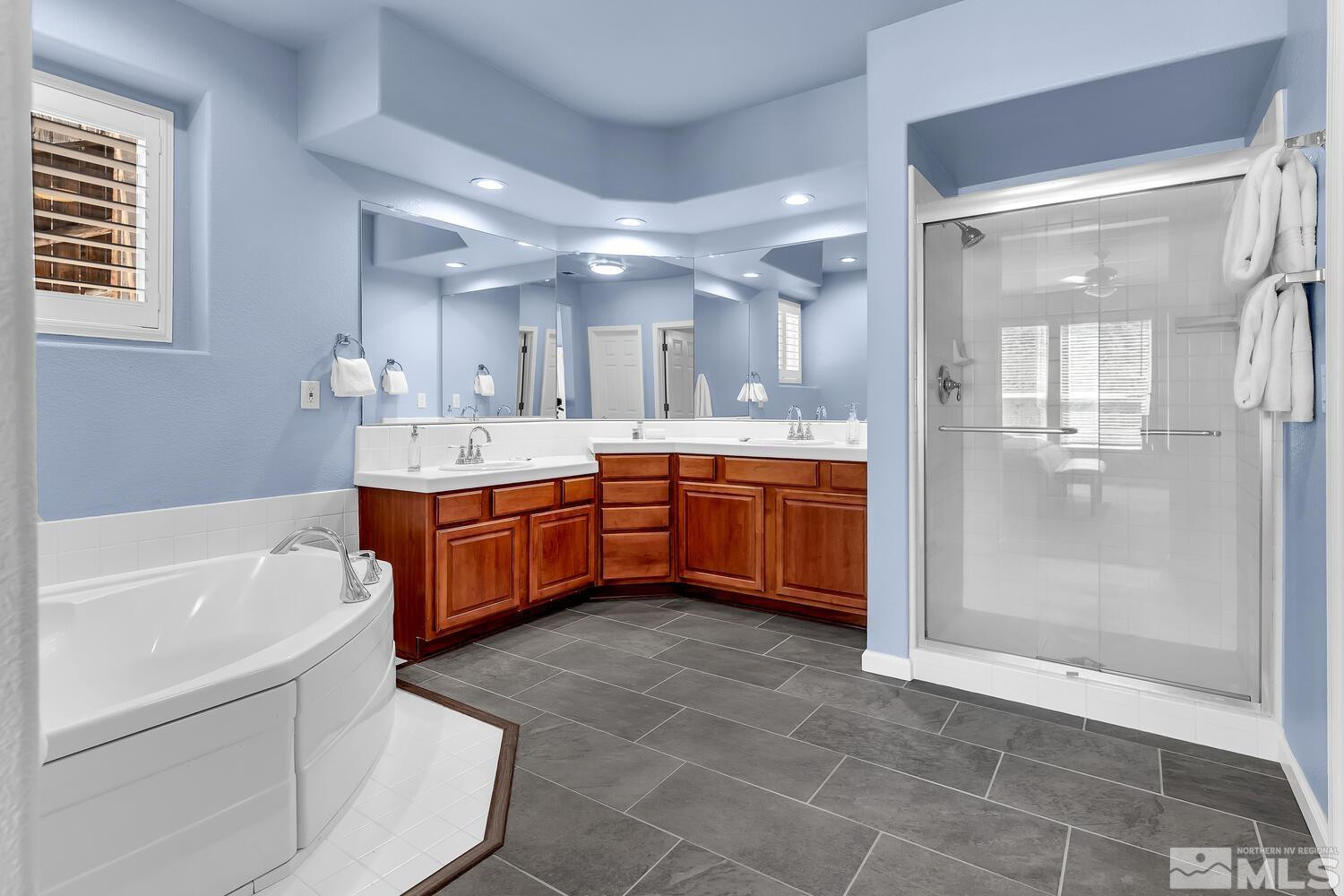 4965 Pinebluff Trail Reno, NV 89519 - Photo 28 of 40 a large bathroom with a tub a sink shower and mirror