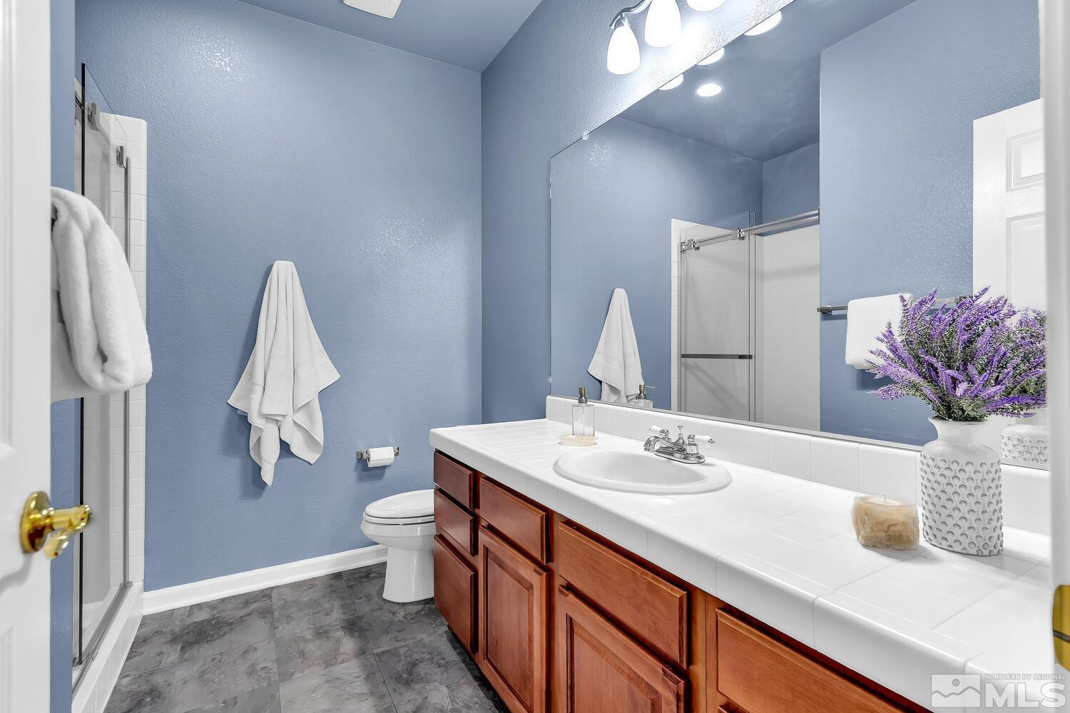 4965 Pinebluff Trail Reno, NV 89519 - Photo 33 of 40 a bathroom with a sink a toilet and mirror