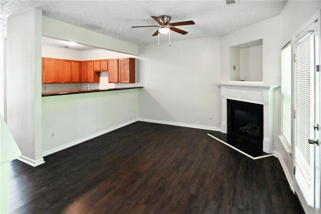 2537 Walden Lake Drive Decatur, GA 30035 - Photo 4 of 22 an empty room with wooden floor fireplace and windows