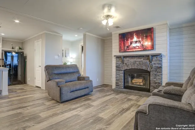 a living room with furniture a fireplace and a flat screen tv
