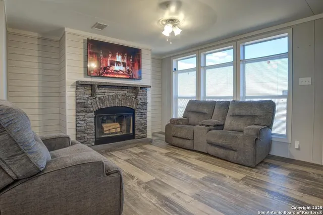 a living room with furniture a fireplace and a flat screen tv