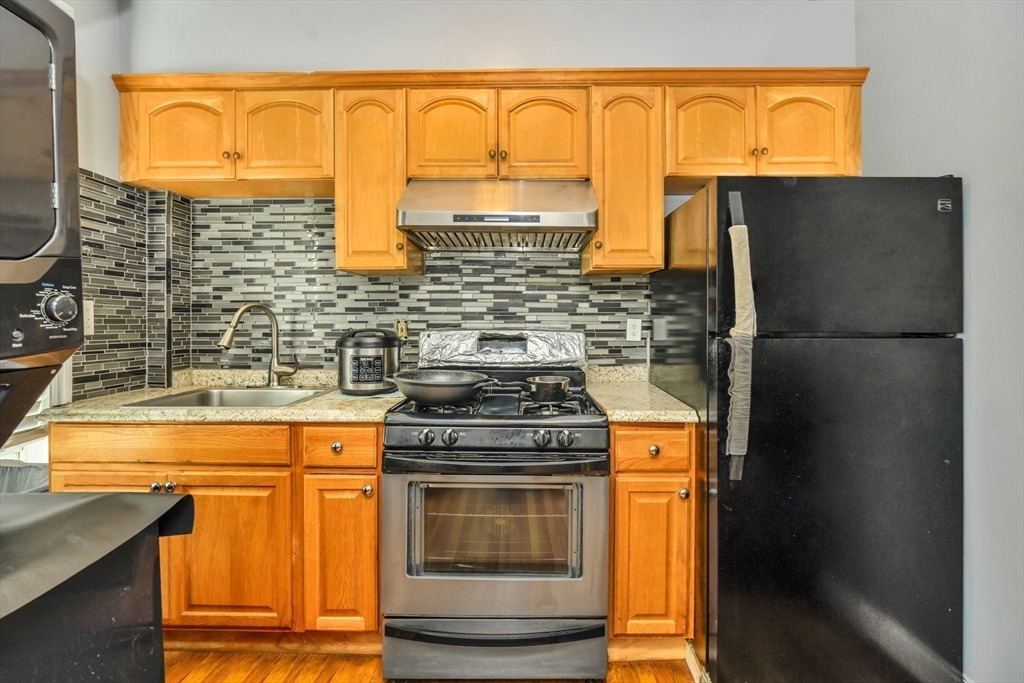5-7 Everett Avenue, Unit 52 Boston, MA 02125 - Photo 3 of 12 a kitchen with stainless steel appliances granite countertop a stove and a refrigerator