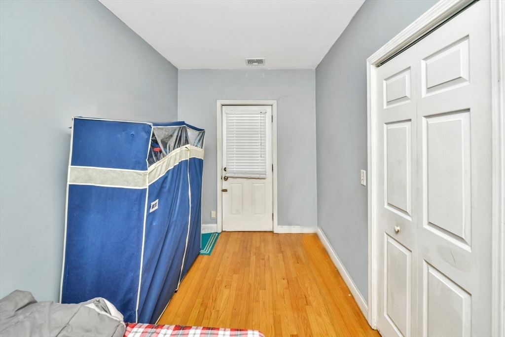 5-7 Everett Avenue, Unit 52 Boston, MA 02125 - Photo 10 of 12 a bedroom with a bed and wooden floor