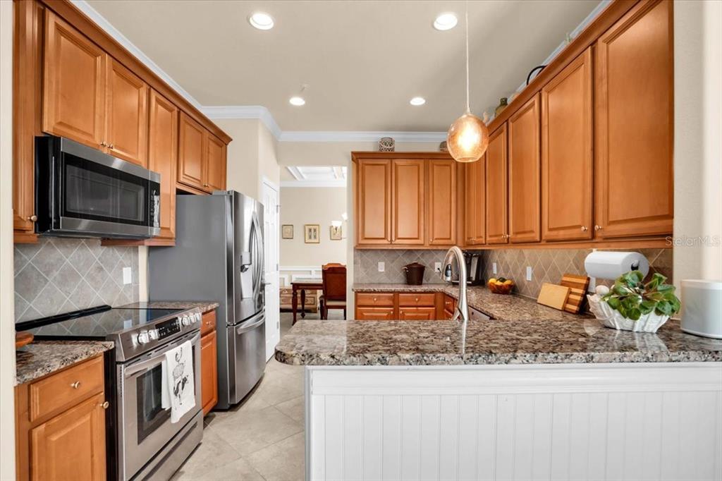 20201 Ragazza Circle, Unit 201 Venice, FL 34293 - Photo 22 of 58 a kitchen with stainless steel appliances granite countertop a stove a sink and a microwave