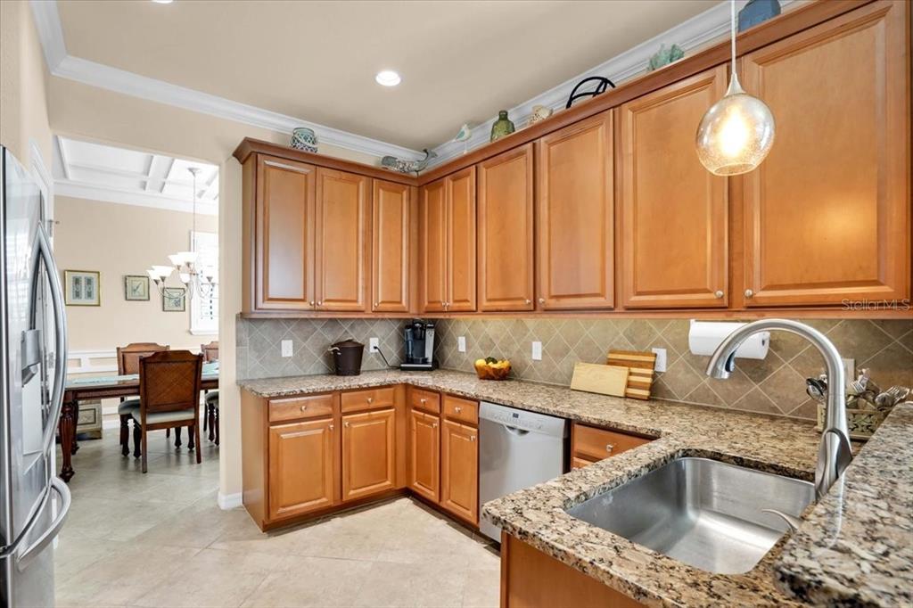 20201 Ragazza Circle, Unit 201 Venice, FL 34293 - Photo 23 of 58 a kitchen with stainless steel appliances granite countertop a sink dishwasher and cabinets with wooden floor