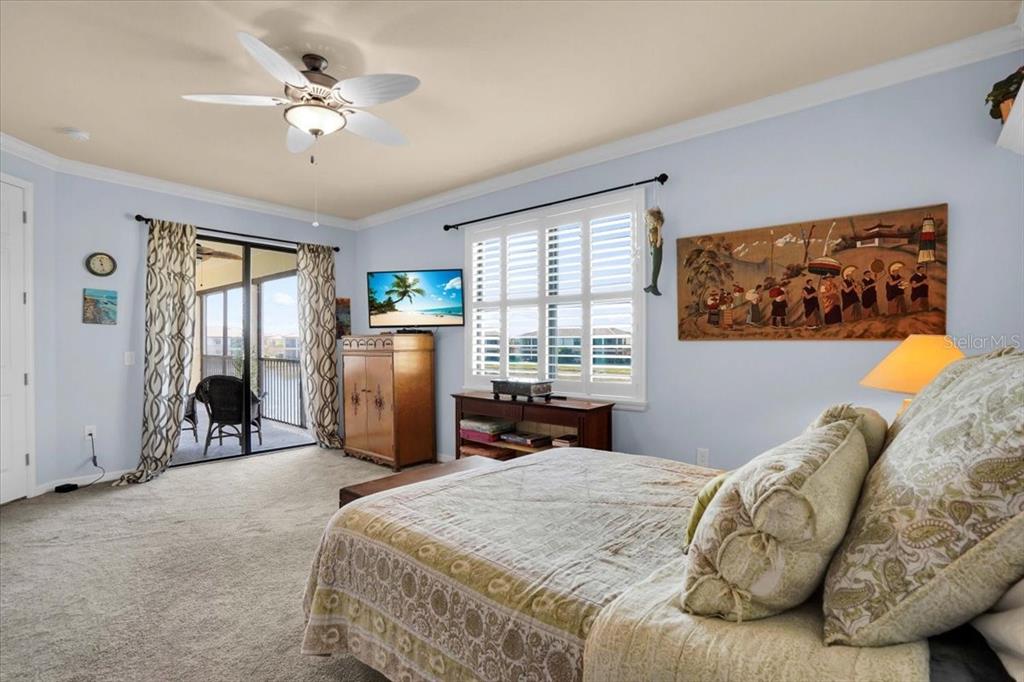 20201 Ragazza Circle, Unit 201 Venice, FL 34293 - Photo 30 of 58 a bedroom with a bed and a chandelier