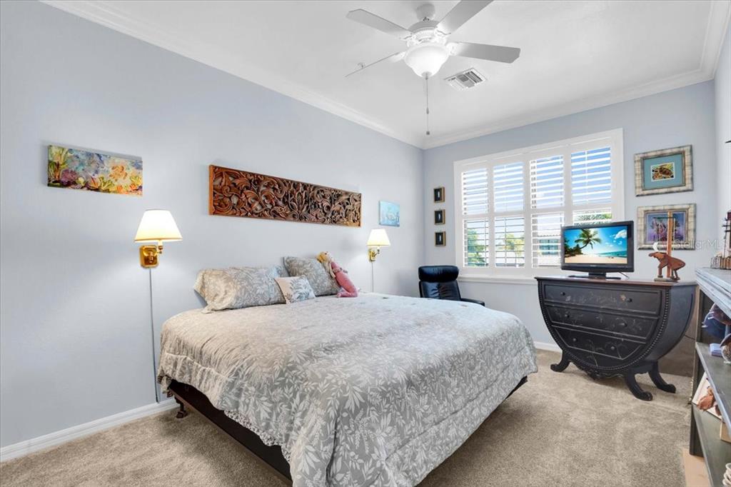 20201 Ragazza Circle, Unit 201 Venice, FL 34293 - Photo 34 of 58 a bedroom with a bed and a chandelier