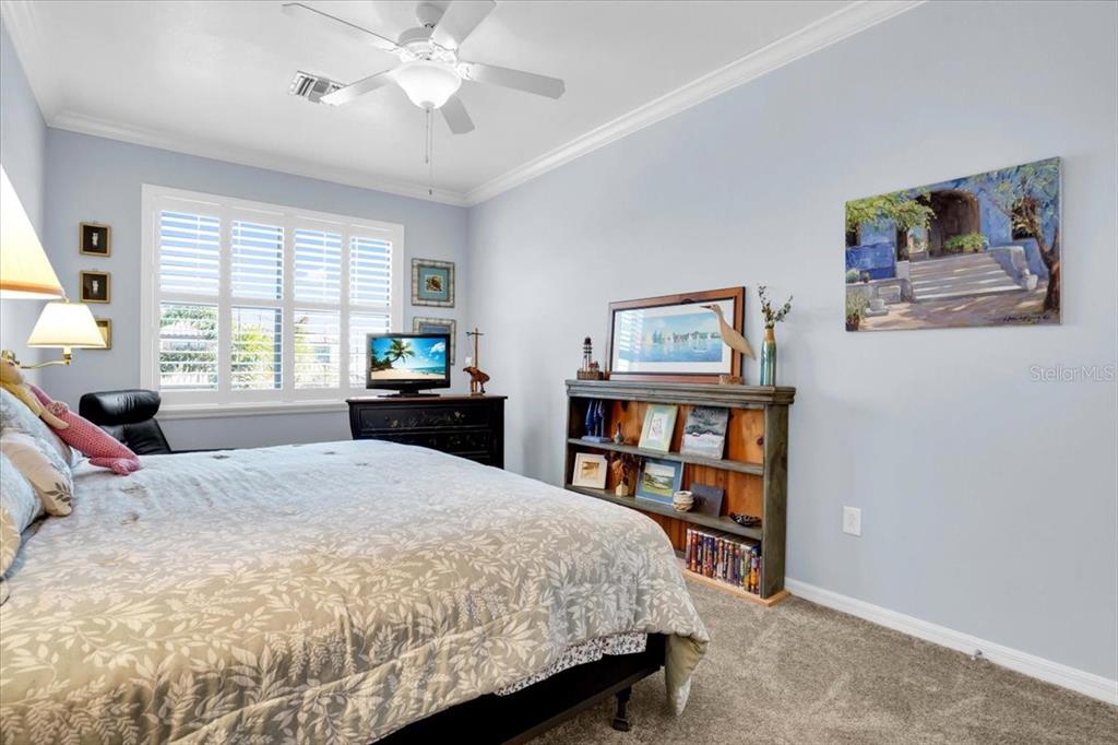 20201 Ragazza Circle, Unit 201 Venice, FL 34293 - Photo 35 of 58 a bedroom with a bed a dresser and a book shelf