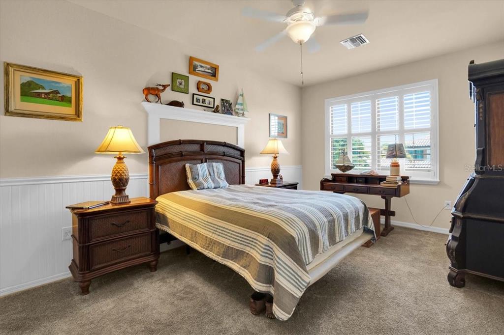 20201 Ragazza Circle, Unit 201 Venice, FL 34293 - Photo 39 of 58 a bedroom with a bed and a chandelier