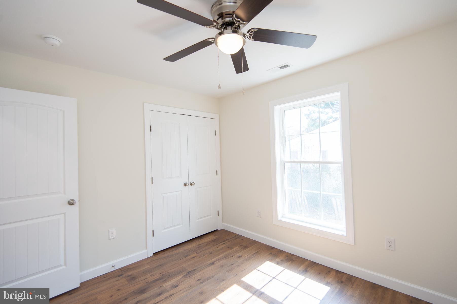 406 Charles Street Hurlock, MD 21643 - Photo 11 of 17 wooden floor in an empty room with a window