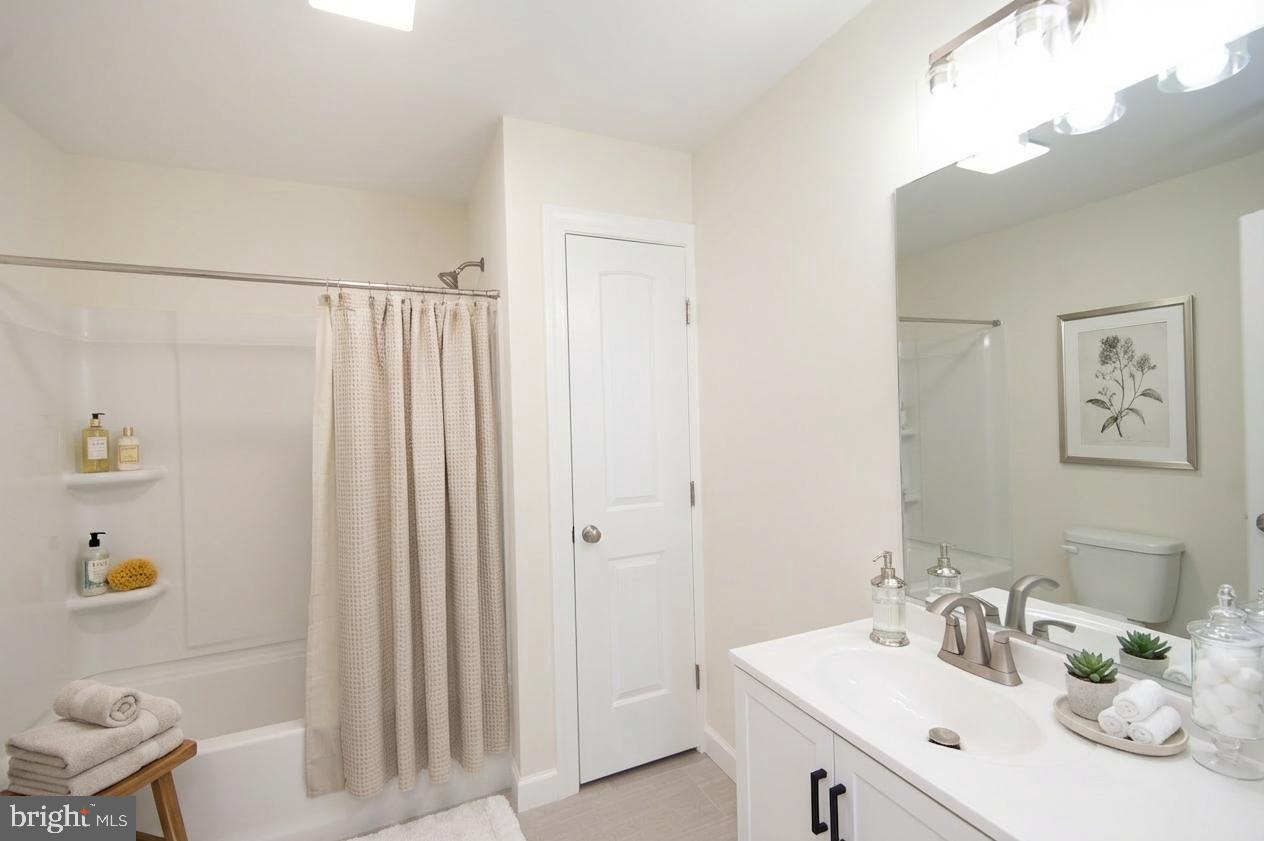 406 Charles Street Hurlock, MD 21643 - Photo 17 of 17 a bathroom with a sink a mirror and a shower