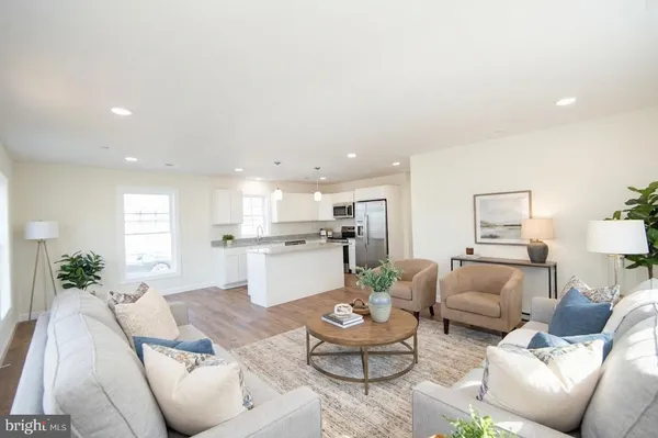 a living room with furniture and view of kitchen