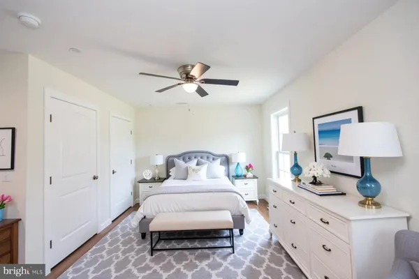 a bedroom with a bed and a lamp on dresser