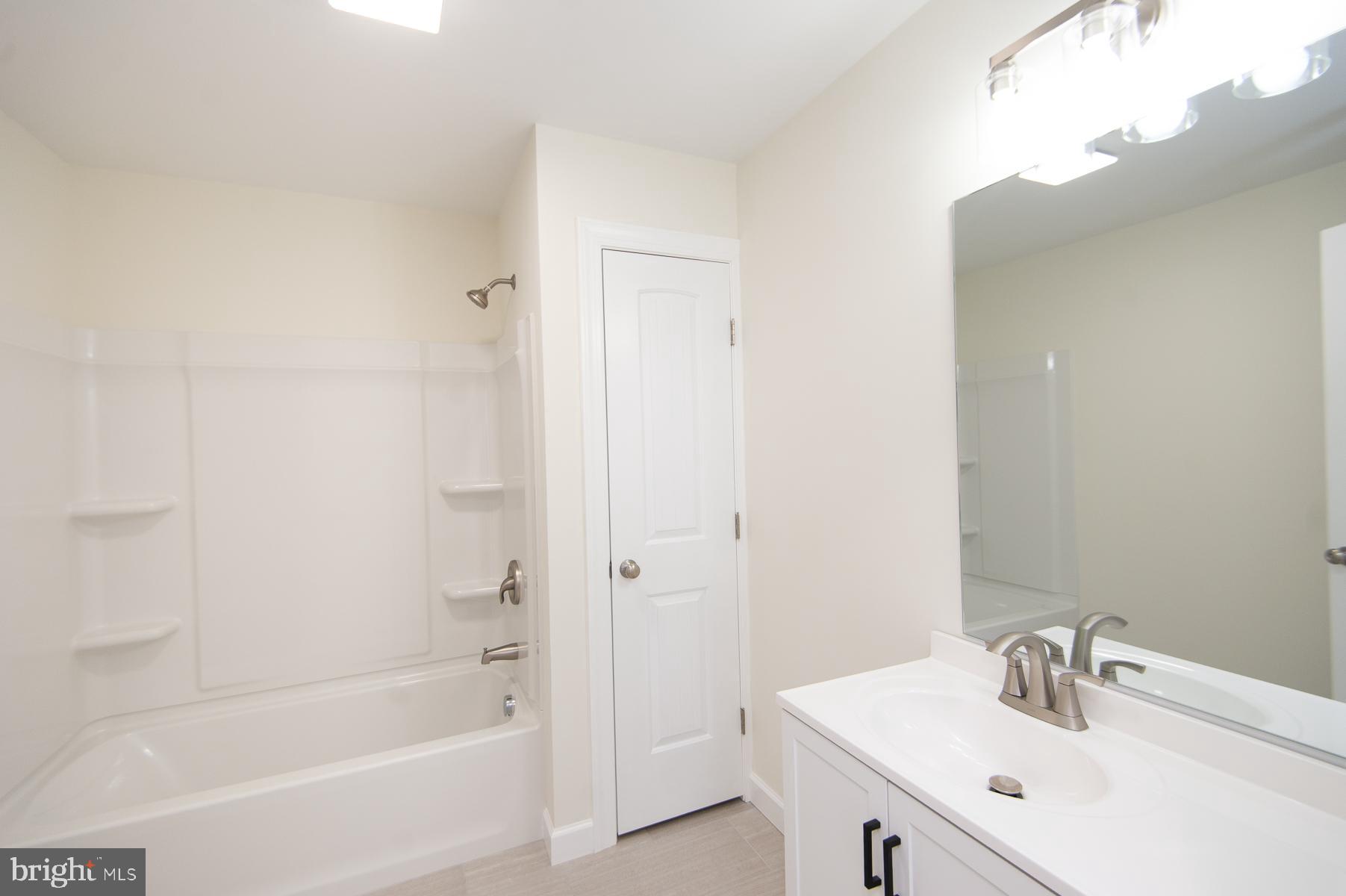 406 Charles Street Hurlock, MD 21643 - Photo 10 of 17 a bathroom with a bathtub a sink and a mirror