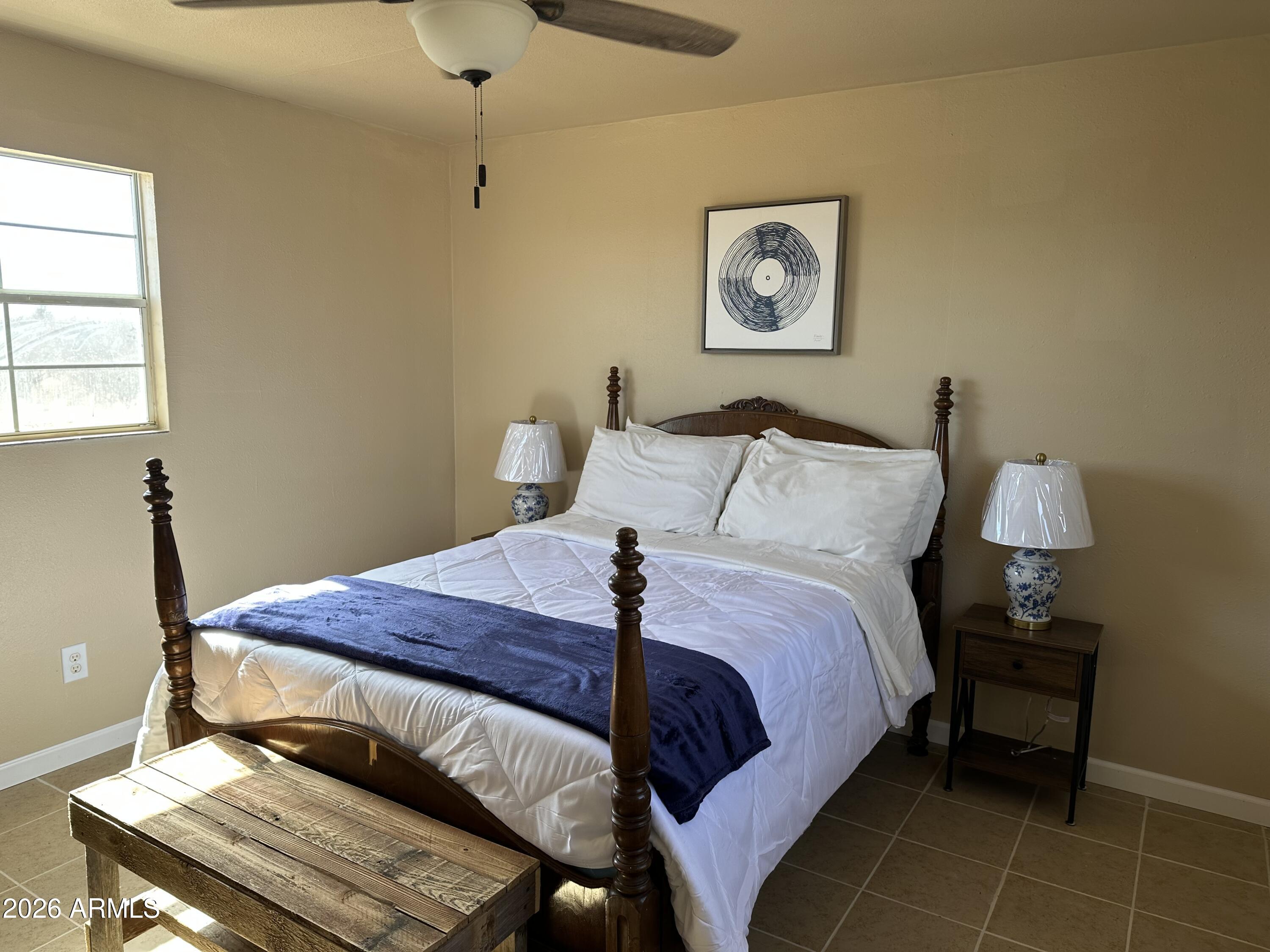5778 South Kino Road Hereford, AZ 85615 - Photo 6 of 18 a bed sitting in a bedroom next to a window