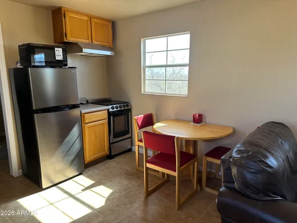 a kitchen with stainless steel appliances granite countertop a table chairs and a refrigerator