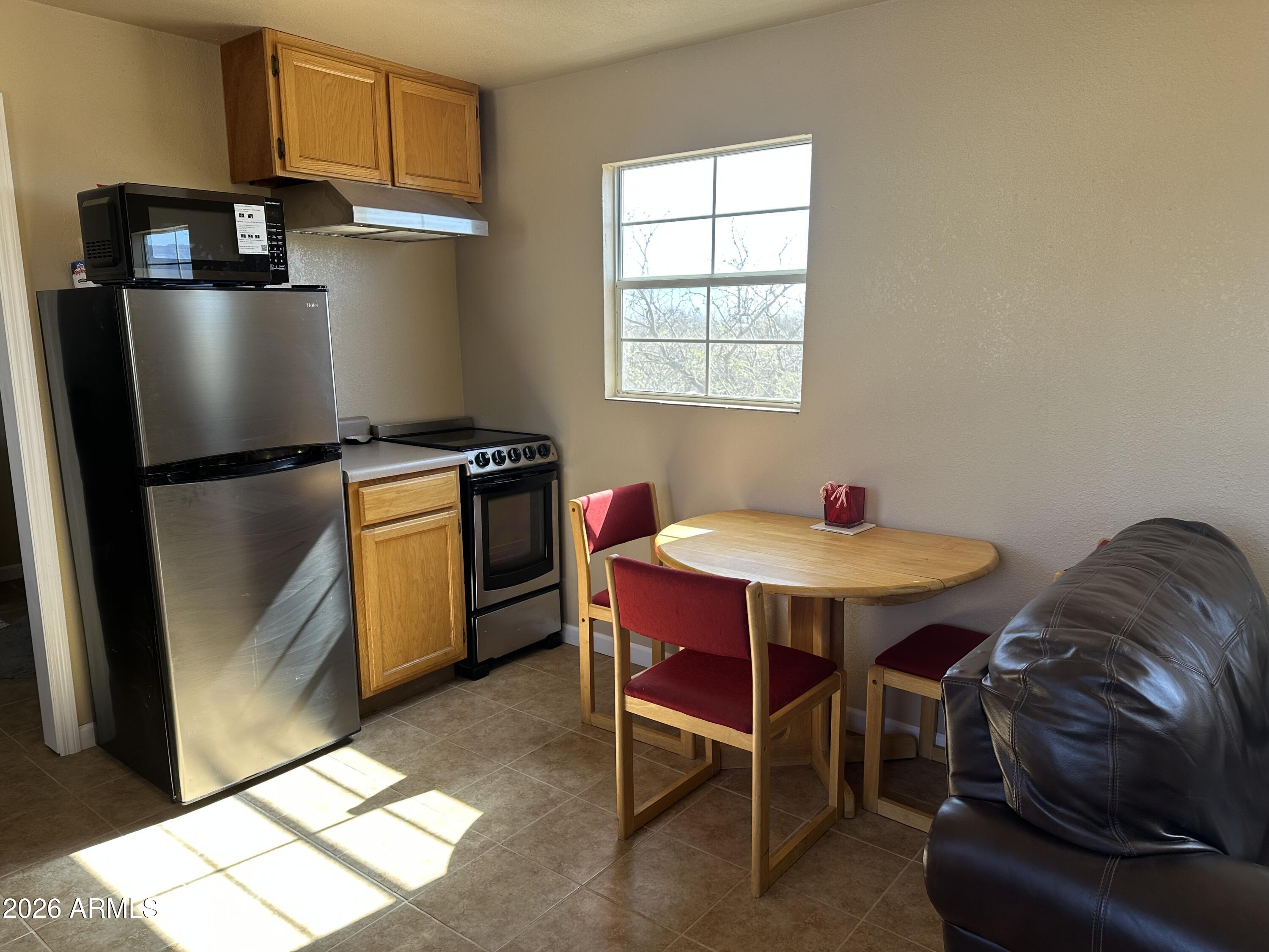 5778 South Kino Road Hereford, AZ 85615 - Photo 10 of 18 a kitchen with stainless steel appliances granite countertop a table chairs and a refrigerator