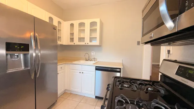 a kitchen with stainless steel appliances granite countertop a refrigerator and a stove